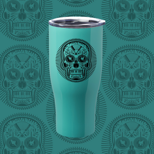 Teal tumbler with a black sugar skull design on its surface.